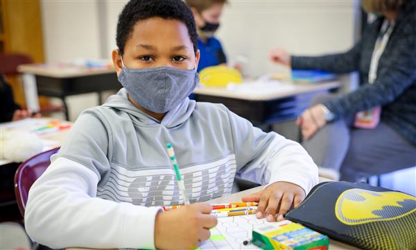 Boy works on paper kite
